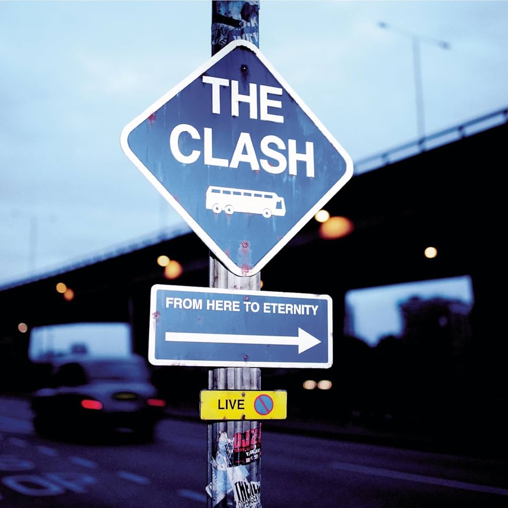 Cover de l'album From Here to Eternity de The Clash. Sur un fond de ciel bleu-gris, on voit une bretelle d'autoroute et une voiture qui s'&eacute;loigne en arri&egrave;re plan, et en premier plan un poteau avec un panneau "THE CLASH" avec un pictogramme d'autocar, un deuxi&egrave;me panneau "From here to eternity" avec une fl&egrave;che qui point vers la droite, et un petit panneau "LIVE" jaune avec un signe interdit de stationner. Sur le bas du poteau, il y a des stickers &agrave; moiti&eacute; arrach&eacute;s.