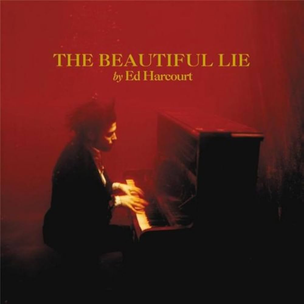 Cover de l'album The Beautiful lie d'Ed harcourt. On voit le chanteur assis &agrave; un piano, et toute la photo est baign&eacute;e dans un fond rouge presque mena&ccedil;ant.