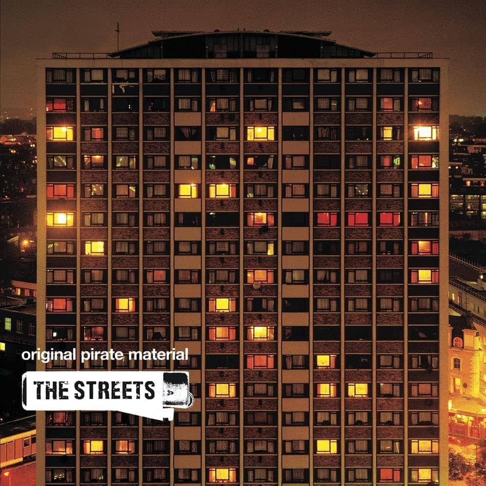 Cover de l'album Original Pirate Material de The Streets. C'est une photo de nuit d'une tour d'immeuble &agrave; Londres. La fa&ccedil;ade de l'immeuble prend presque toute l'image. Certaines fen&ecirc;tres sont &eacute;clair&eacute;es. Le nom de l'album et celui du groupe, ainsi que le dessin stylis&eacute; d'un briquet sont inscrits en blanc en bas &agrave; gauche de la pochette.