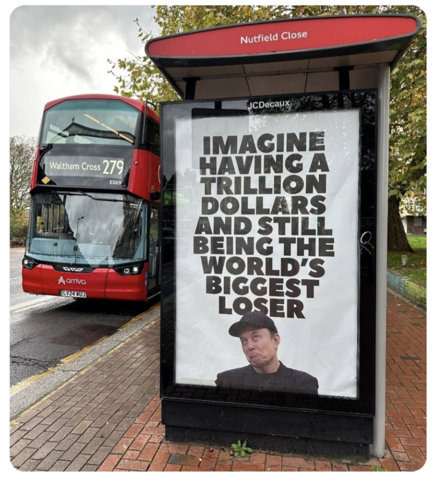 Photo d'un arrêt de bus londonien avec une énorme affiche publicitaire - une photo d'Elon Musk avec une expression ridicule et la phrase Imagine having a trillion dollars and still being the world's biggest loser