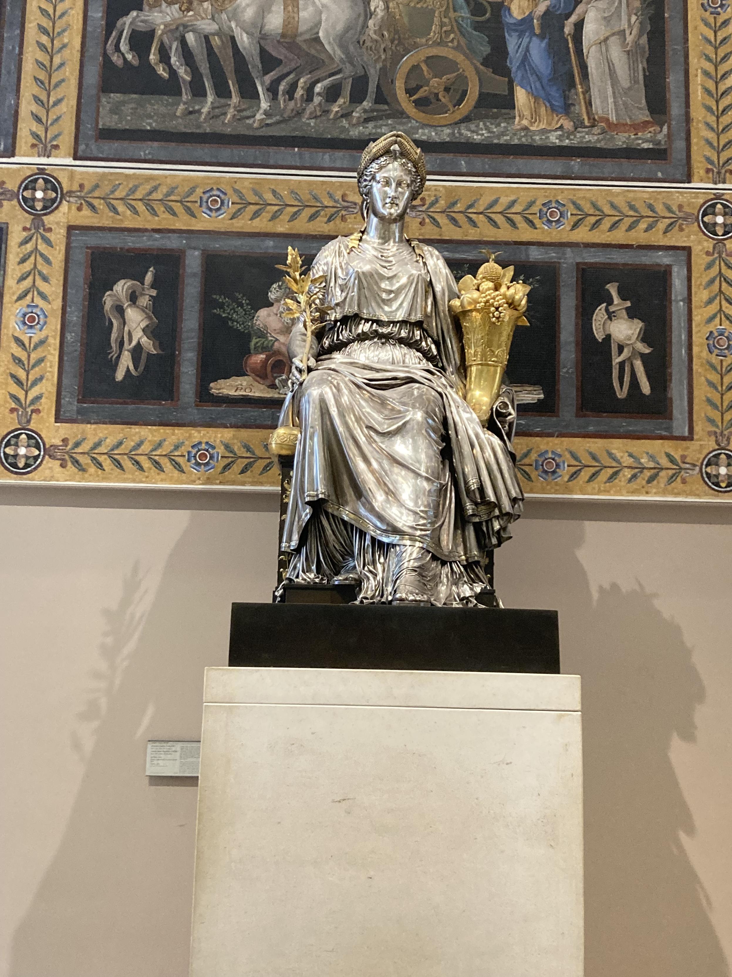 Statue d’une femme assise, tout en métal argenté et doré