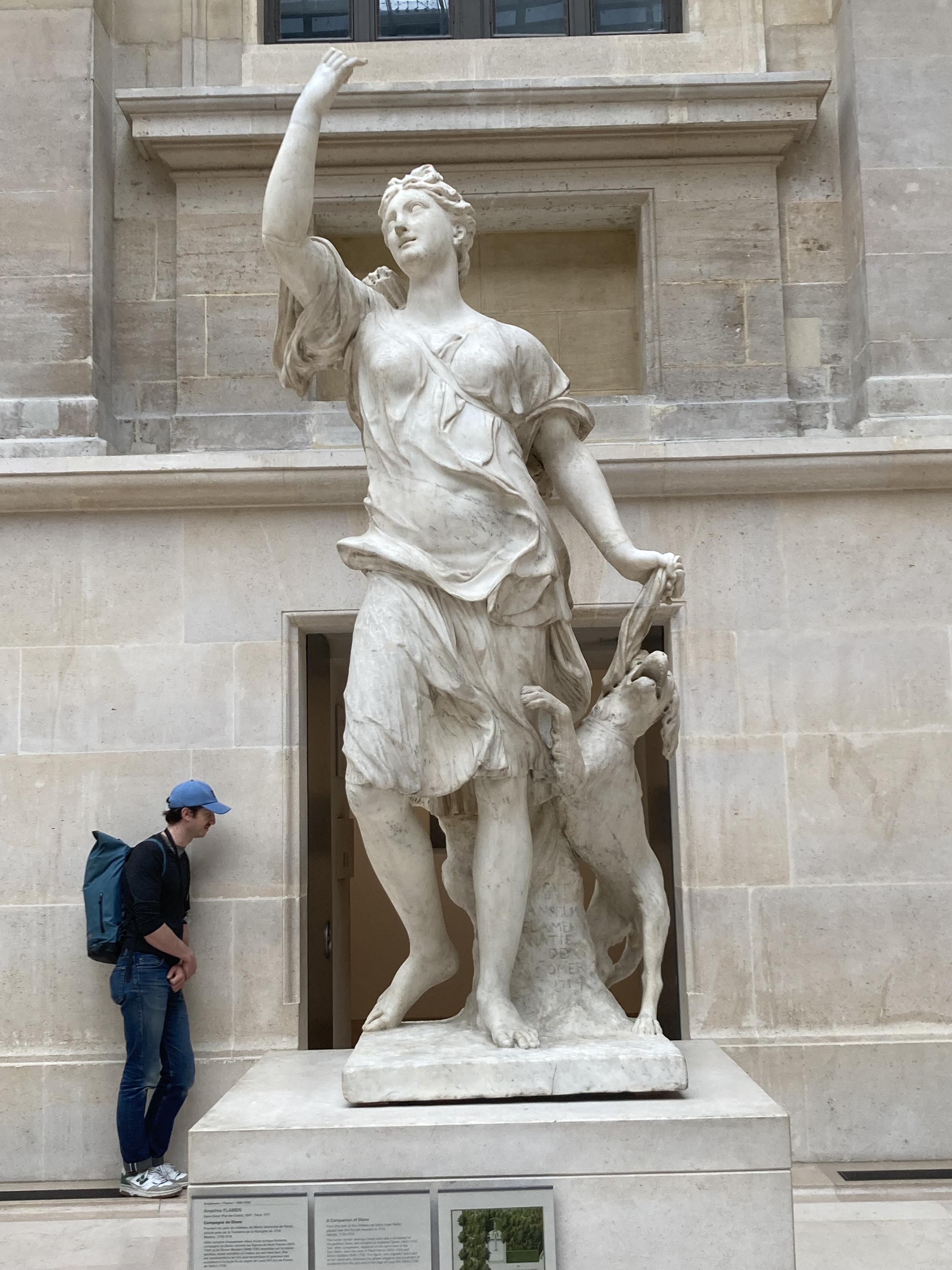 Sculpture d’une femme qui tient son bras en l’air et regarde sa main comme si elle prenait un selfie