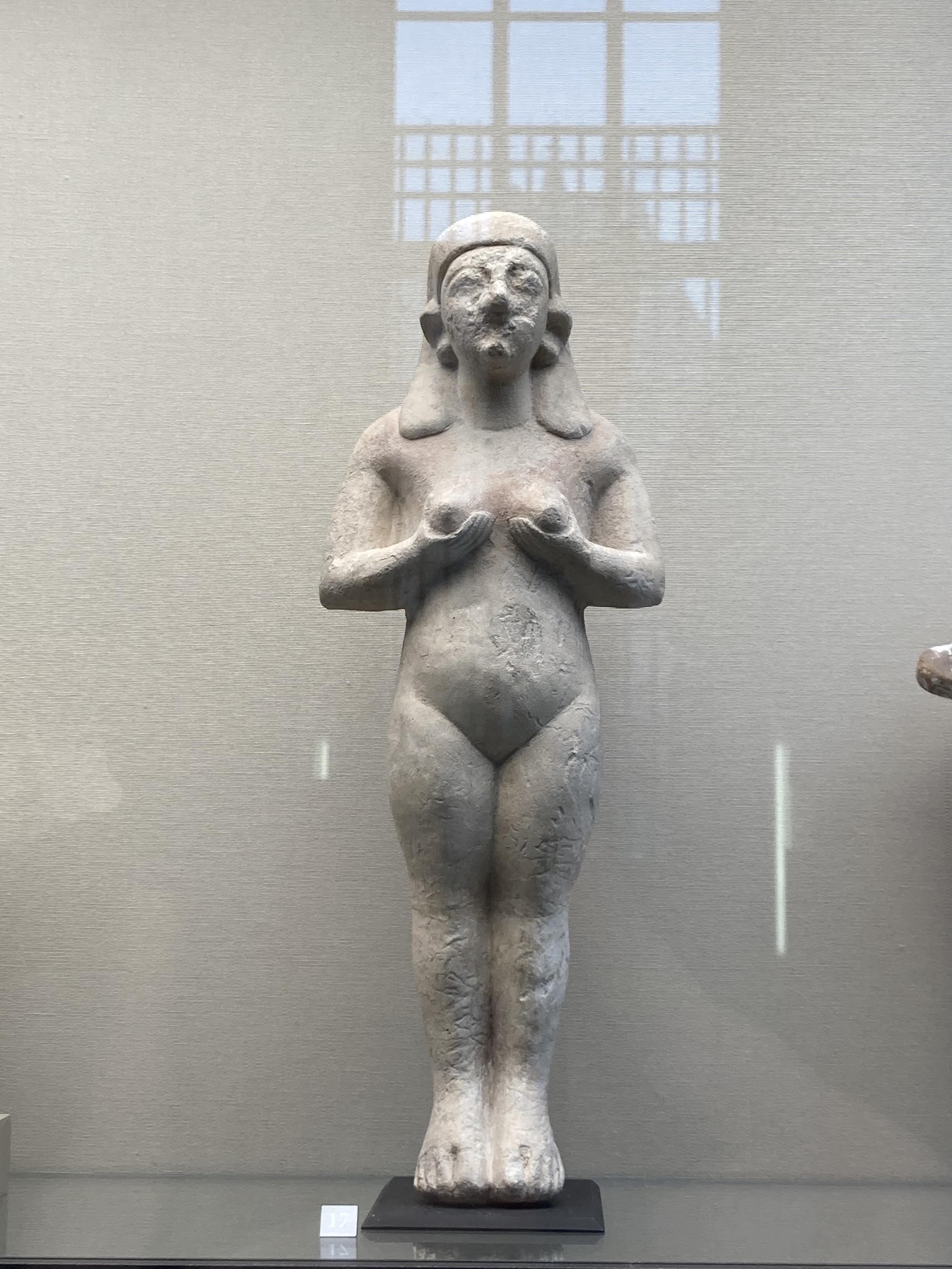 Petite sculpture d’une femme nue qui tient ses seins dans ses mains
