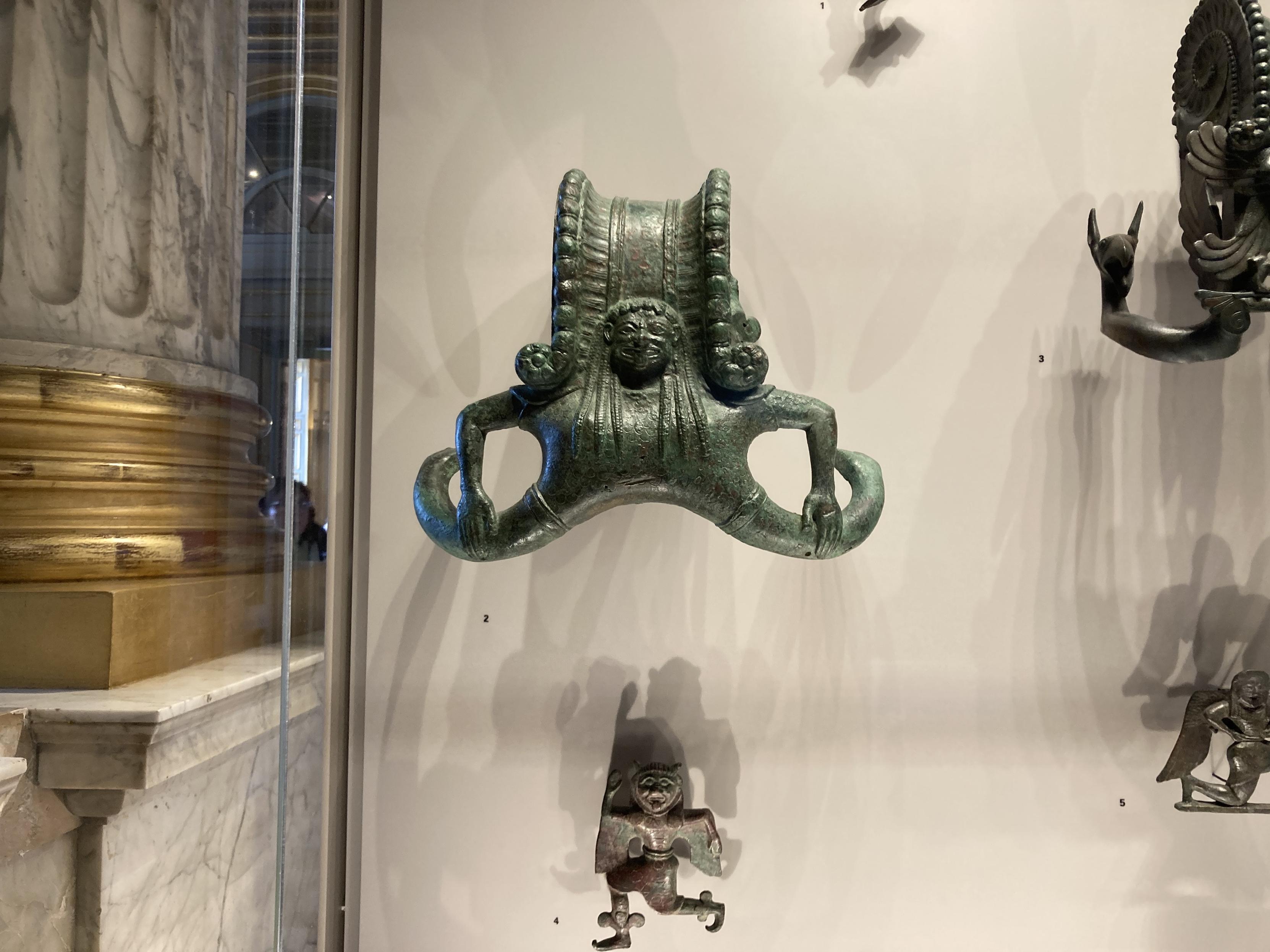 Sculpture d’une sorte de sirène à deux queues, en grand écart facial