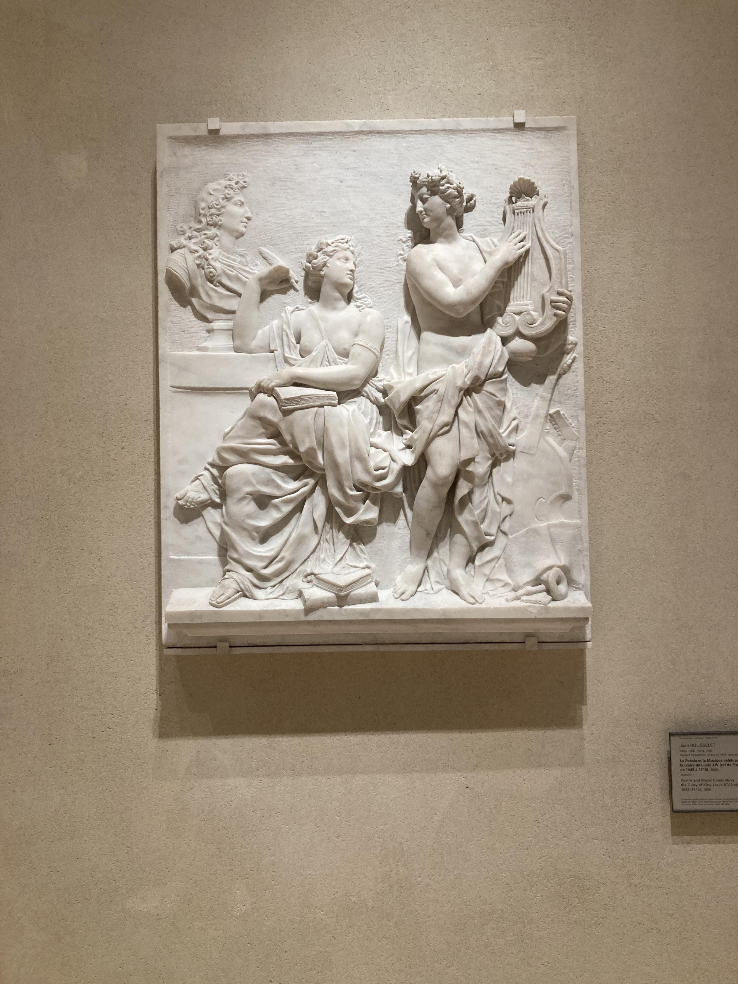 2 femmes, à peine cachées par des draperies admirent le buste d’un homme entièrement habillé