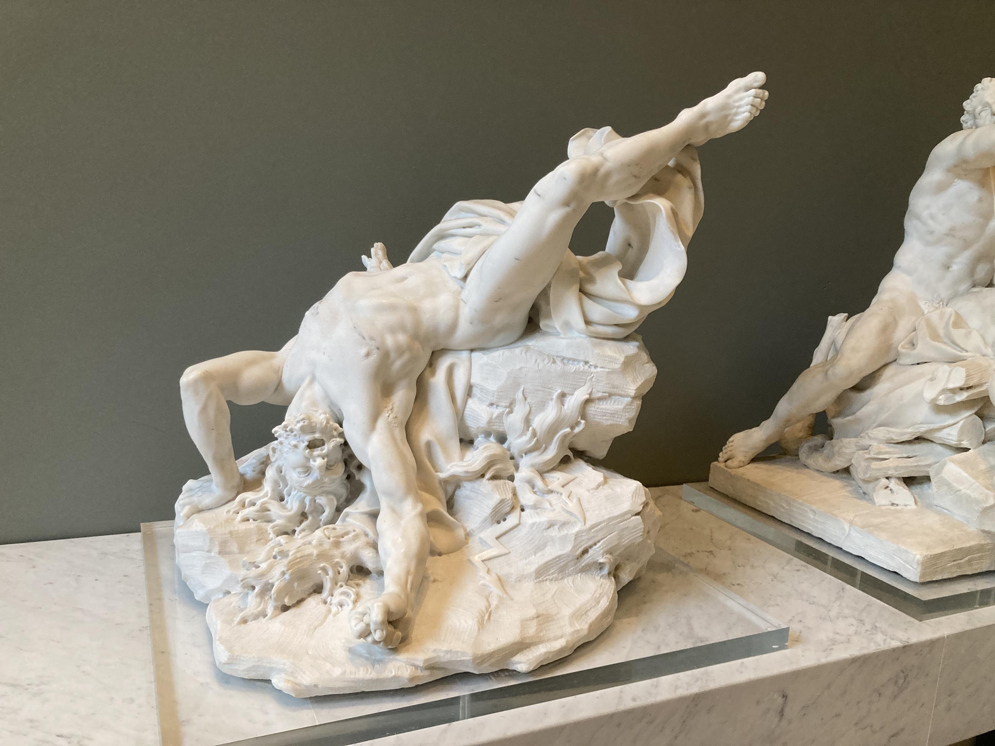 Statue d’un homme avec le bassin sur le bord d’un rocher, une jambe en l’air, et le haut du corps qui pend dans le vide