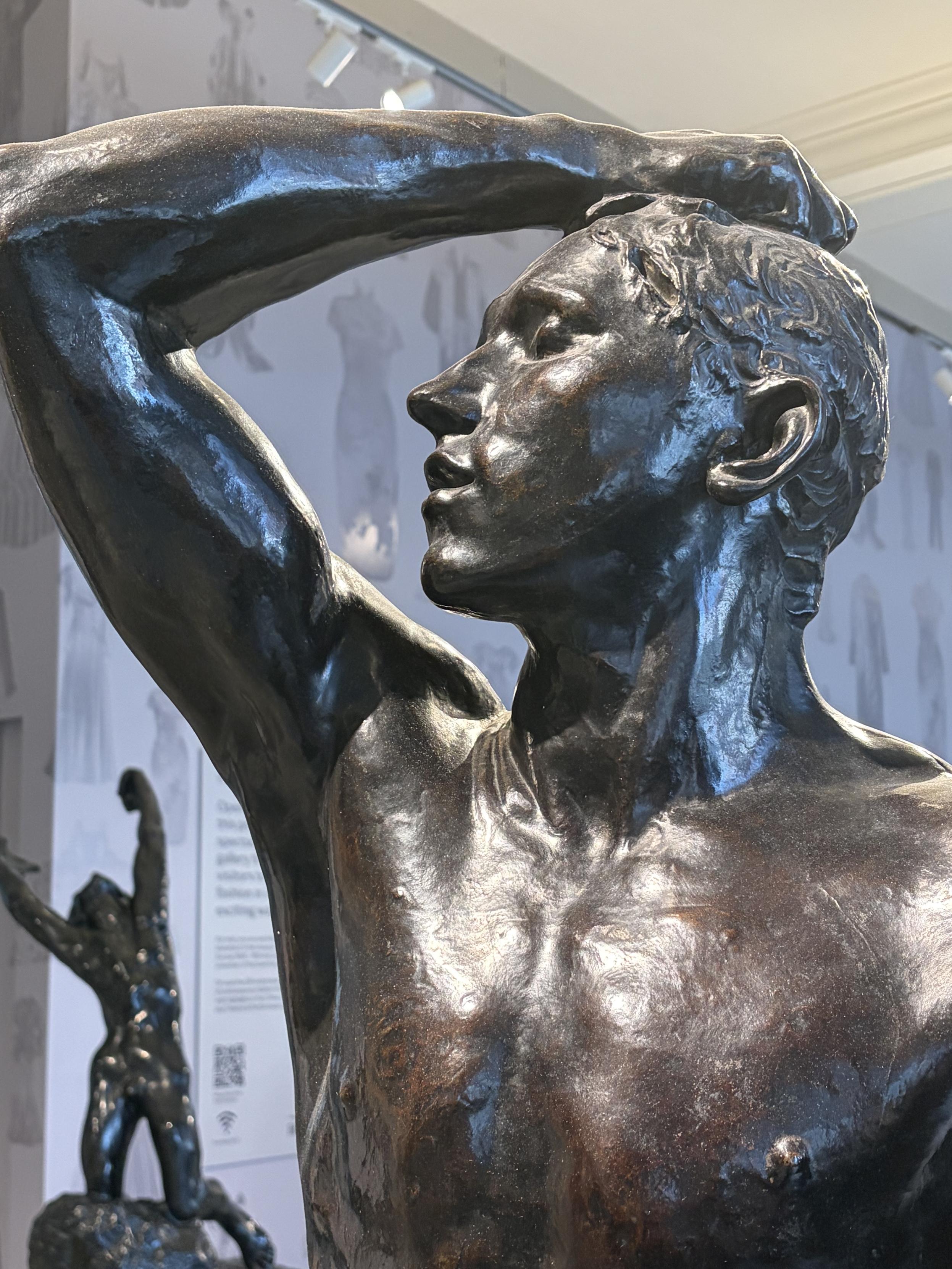 Gros plan sur la t&ecirc;te d&rsquo;une statue. L&rsquo;homme se tient la t&ecirc;te l&eacute;g&egrave;rement relev&eacute;e, avec la main dans les cheveux