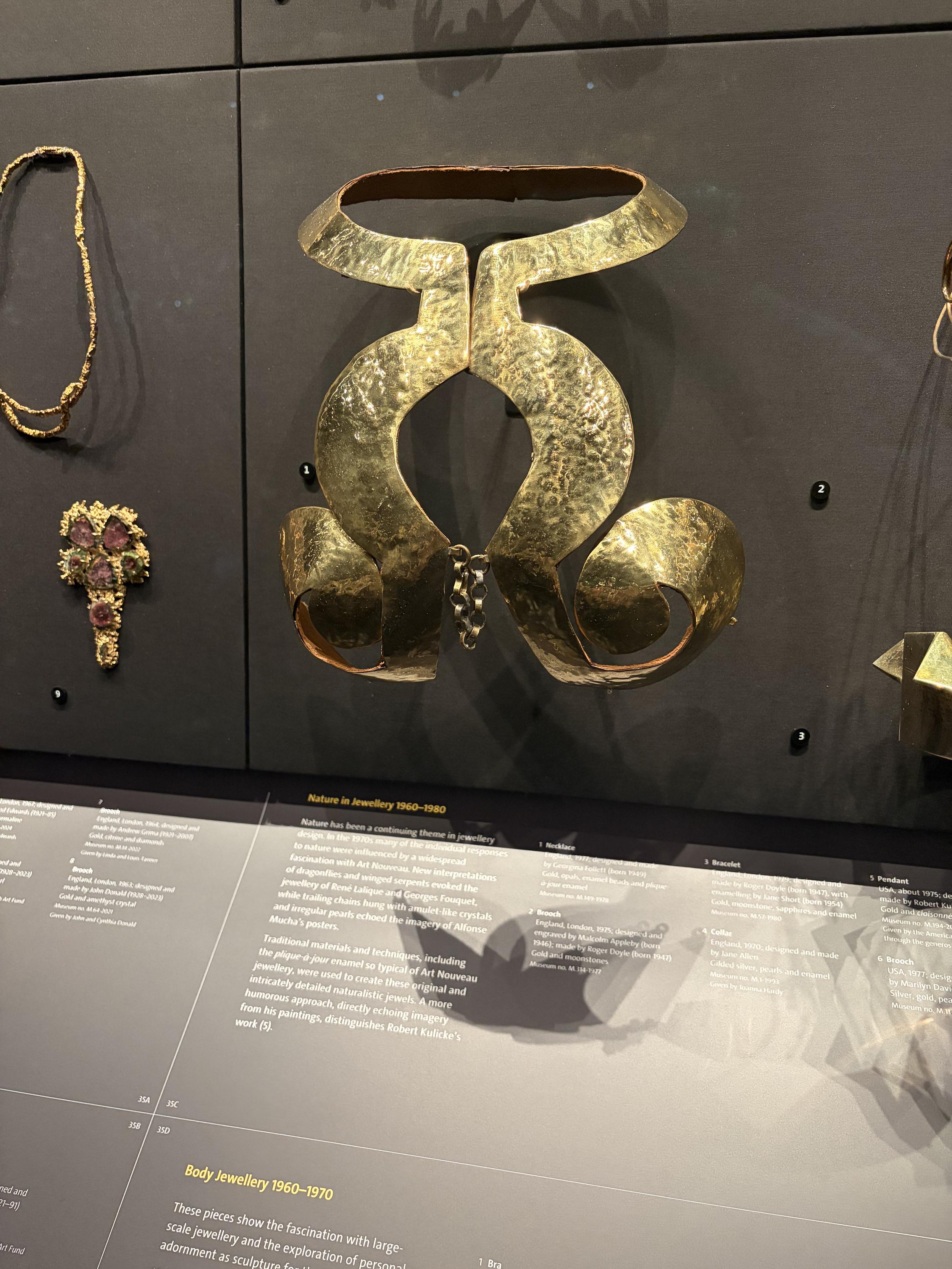 &laquo; Soutien gorge &raquo; en m&eacute;tal, attach&eacute; &agrave; un large collier rigide