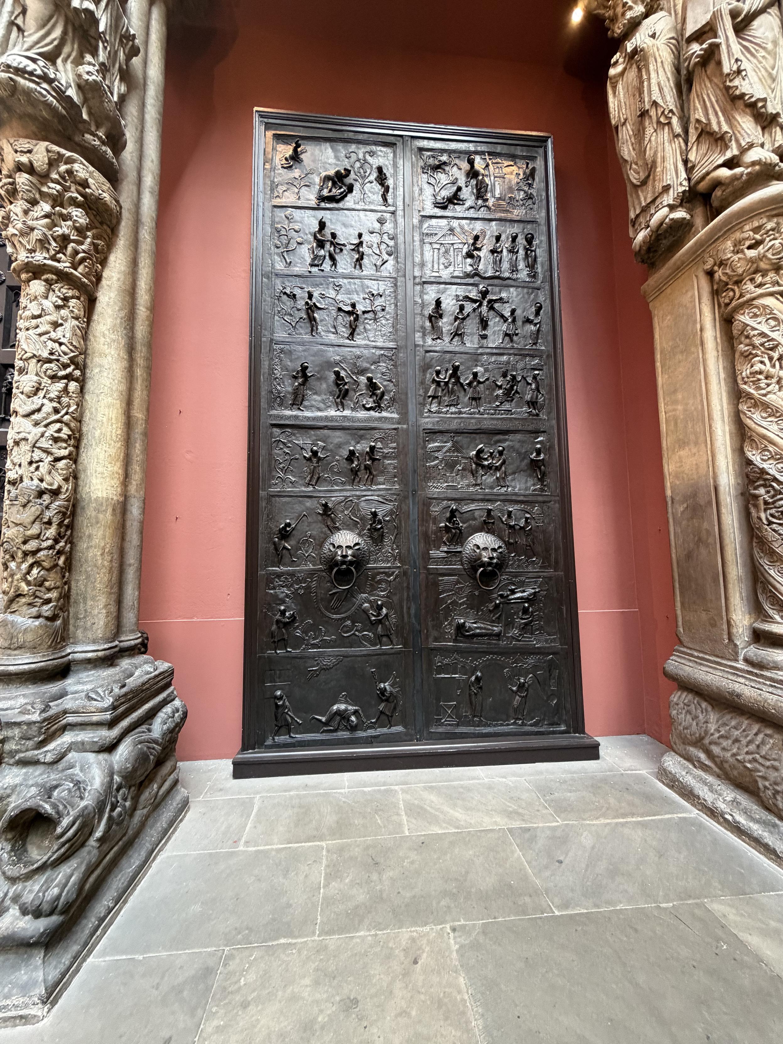 Double porte en m&eacute;tal fonc&eacute;, avec plein de sculptures en bas relief dessus