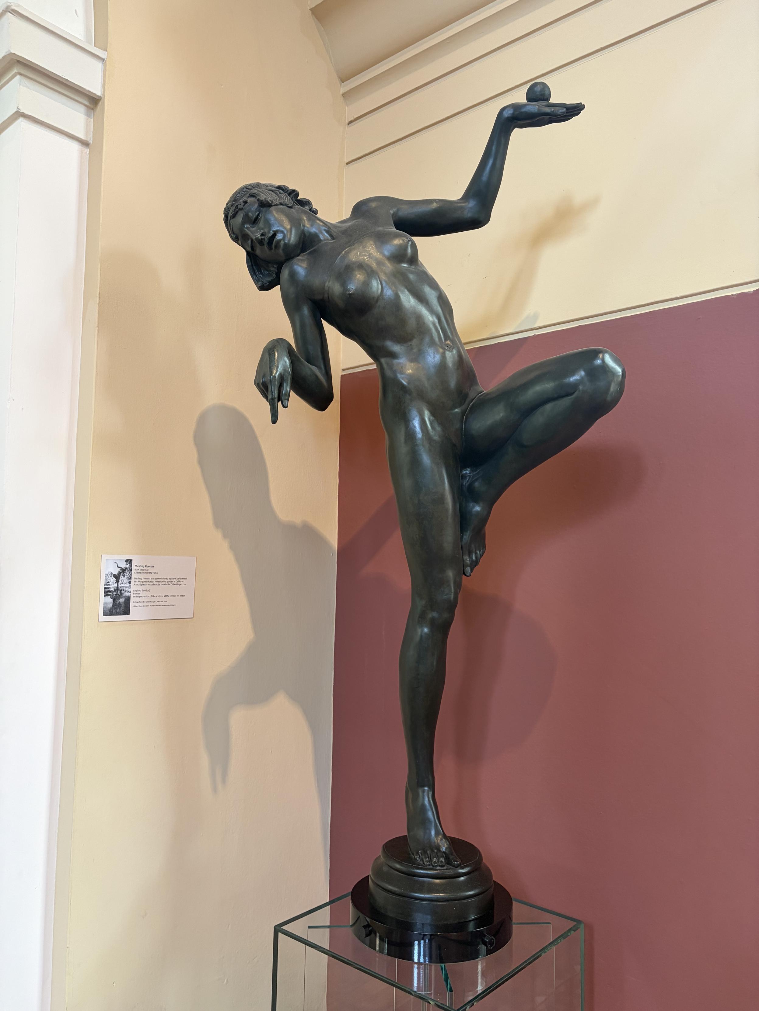 Sculpture d&rsquo;une femme nue, en &eacute;quilibre sur un pied, une main en l&rsquo;air, le corps penche en arri&egrave;re, la t&ecirc;te tourn&eacute;e vers le sol et l&rsquo;autre main pointant le sol